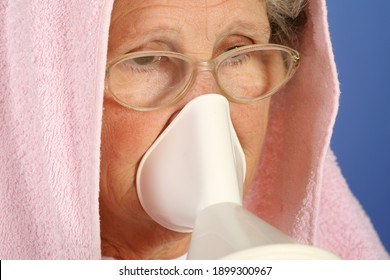 Close-up 65-year-old sick woman using inhaler to treat colds and sore throat