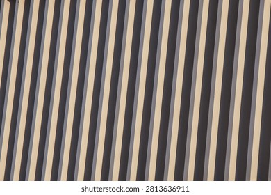 Close-up abstract image featuring diagonal stripes in beige and dark gray tones, creating a visually striking pattern with alternating light and shadow contrasts.