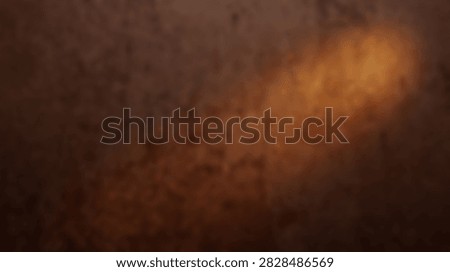 A close-up abstract image featuring a textured surface with a warm, glowing light emanating from the right side.