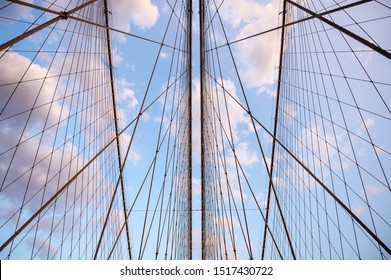 Close-up abstract view of criss-crossed steel suspension cables of the Brooklyn Bridge under scenic sunset skies - Powered by Shutterstock