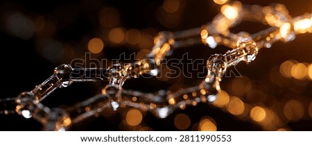A close-up, abstract view of a molecular structure or chain, illuminated by warm, golden bokeh lights in the background, creating a sense of depth and wonder.