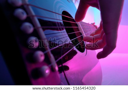 Closeup of an acoustic guitar played by a girl