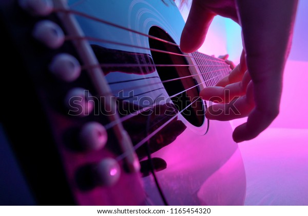 Closeup of an\
acoustic guitar played by a\
girl