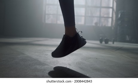 Closeup Active Woman Legs Jumping With Skipping Rope. Fitness Girl Feet Jumping On Jump Rope In Modern Gym. Unrecognizable Sportswoman Wearing Sneakers For Intense Training 