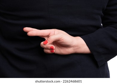 Close-up of adult businesswoman in formalwear making bad luck gesture with fingers crossed behind back as corporate concept isolated on white studio background - Powered by Shutterstock