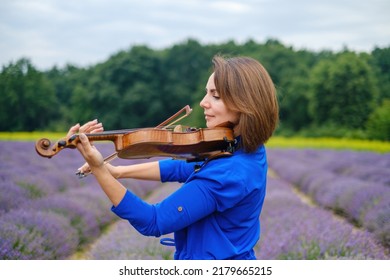 Close-up Adult Caucasian Woman Violinist Playing Violin On Summer Lavender Field, Romantic Musician In Blue Dress Enjoying Walking On Nature, Back View