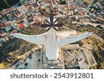 Close-up, aerial view from above of the Monteagudo statue, arms outstretched with overlooking to colorful rooftops and winding paths. Landmarks, monuments concept. Murcia, Province of Alicante. Spain
