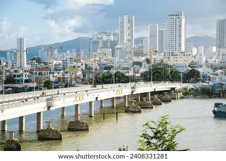 Close-up aerial view downtown Nha Trang, Khanh Hoa with skyscrapers, towers and building under construction, Tran Phu bridge near the mouth of Cai River, wooden fishing boats Cu Lao Village. Vietnam