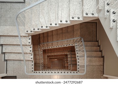 A close-up aerial view of a modern spiral staircase. The stairs are made of white marble and have a simple, curved design. The railing is made of thin, white metal rods.
 - Powered by Shutterstock