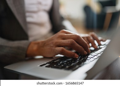Close-up of African American businesswoman typing an e-mail while working on laptop. 