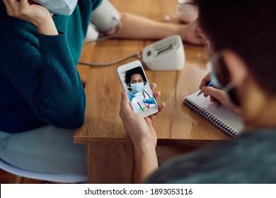 Close-up Of African American Doctor Having Video Call With A Couple And Advising Them About Medicine For High Blood Pressure. 