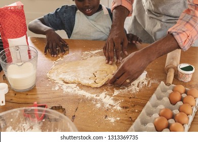 Close-up of African American father and son baking cookies in kitchen at home. Social distancing and self isolation in quarantine lockdown for Coronavirus Covid19
 - Powered by Shutterstock