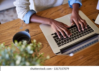 Closeup Of An African American Female Entrepreneur Working Online With A Laptop While Sitting At A Table At Home  