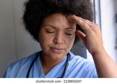 Close-up Of African American Mid Adult Female Nurse With Hand In Hand Suffering From Headache. Unaltered, Healthcare Worker, Stress, Expertise And Occupation Concept.