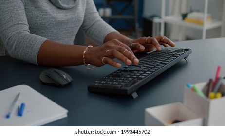 Closeup of african american student hands working at communication project typing information on keyboard using computer sitting at desk in living room. Woman searching business email - Shutterstock ID 1993445702