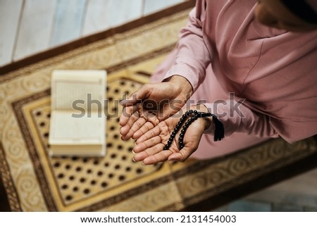Close-up of African American woman using misbaha beads while praying in a mosque.