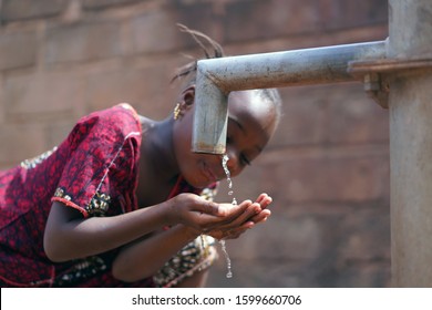 Close-up Of African Black Girl Drinking Potable Water Outdoors