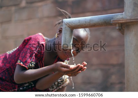 Close-up of African Black Girl Drinking Potable Water outdoors