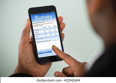 Close-up Of African Businesswoman Filling Online Survey On Mobile Phone