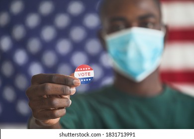 Close-up Of African Man In Mask Holding Sticker With Word Vote