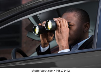 Close-up Of An African Man Sitting Inside Car Looking Through Binocular