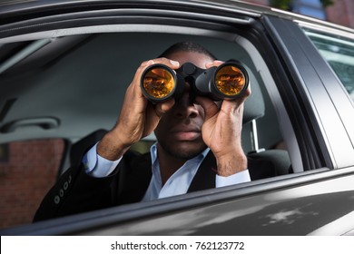 Close-up Of An African Man Sitting Inside Car Looking Through Binocular