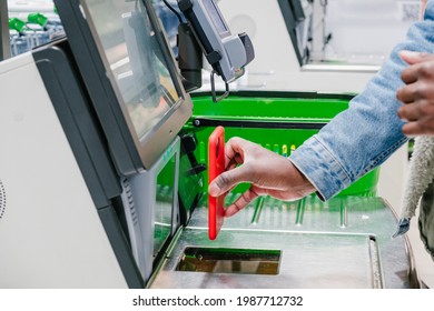 A Close-up Of An African Man's Hand Paying In A Grocery Supermarket At The Checkout With A Contactless Payment Using A Mobile Phone Against The Background Of A Shopping Basket. Contactless Payment