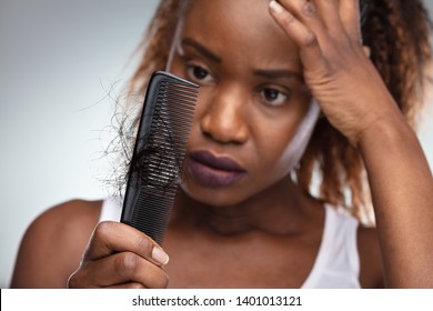 Close-up Of African Shocked Woman Suffering From Hair Loss Problem