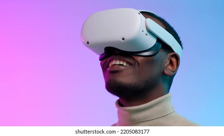 Closeup Of African-American Man Use Ar Goggles Isolated Over Neon Background. Happy Male In Virtual Reality Goggles