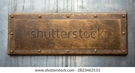 Close-up of an aged brass plaque fixed with fasteners onto a distressed metal facade ideal for signage or architectural concepts.
