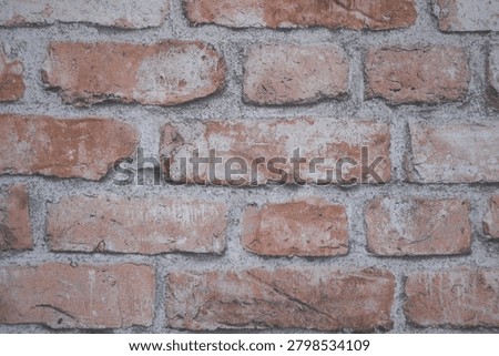 Close-up of an aged red brick wall with visible mortar joints and weathered texture. Detailed masonry background suitable for construction.