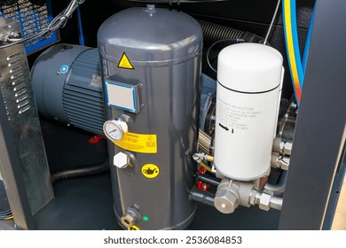 Close-up of an air compressor unit featuring motor, tank, filter, and various components