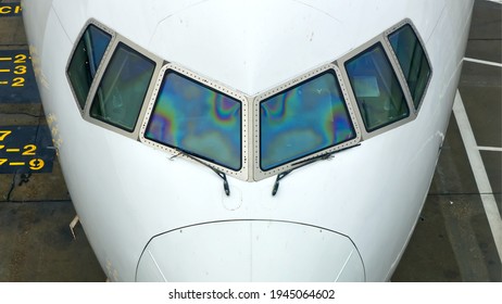 Closeup of an aircraft's cockpit windows and part of its nose.