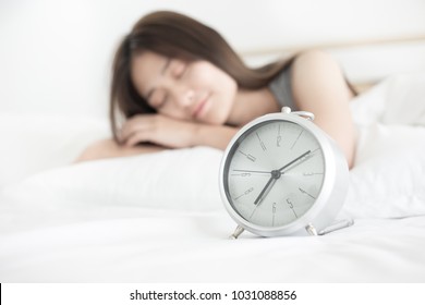 Closeup Alarm Clock In The Morning, Wake Up Time , Woman Sleep On White Bed