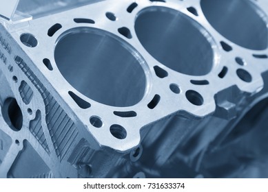 Close-up of the aluminium cylinder block in the light blue scene.Automotive part manufacturing process.