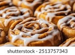 Close-up amateur photo of cinnamon rolls on a clear, soft background, highlighting their delicious, gooey texture.