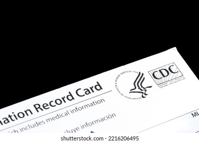 Closeup Of The American Covid-19 Vaccination Record Card Issued By CDC, A Federal Government Organization. Bilingual Text In English And Spanish. Solid Black Background With Negative Copy Space.