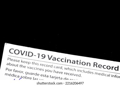 Closeup Of The American Covid-19 Vaccination Record Card Issued By CDC, A Federal Government Organization. Bilingual Text In English And Spanish. Solid Black Background With Negative Copy Space.