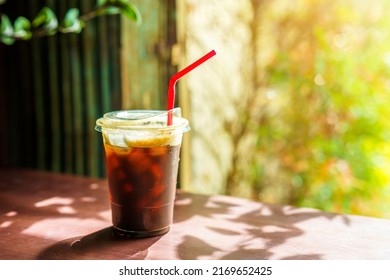 Close-up of Americano ice coffee or black coffee in cup mug on glass wood desk office desk in coffee shop at the cafe in garden,during business work concept