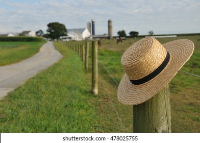 Closeup Of Amish Straw Hat Laying Over Farm Fence Post