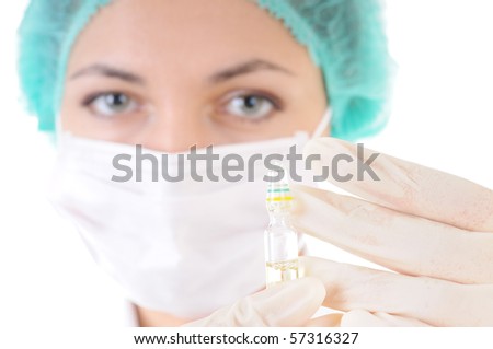 Close-up of a ampule in doctor's hands in gloves with female face out of focus on background