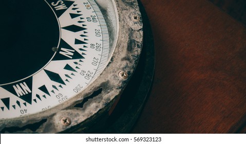 Close-up Of Ancient Boat Compass Aboard On Old Vintage Wood. Vintage Ship Compass.