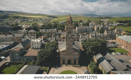 Closeup ancient church at Europe town aerial. Historical architecture attraction at Scotland. Campbeltown city streets with old buildings. European cityscape: historic tourist landmark. Road with cars