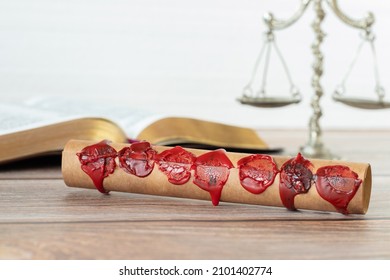 A closeup of an ancient closed scroll with seven seals on a wooden table with Holy Bible Book and old weighing scales against a white background. Christian biblical concept of Revelation's prophecy. - Shutterstock ID 2101402774