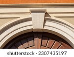 Closeup of an ancient marble arch with keystone and brown wooden door, full frame, photography. Brescia downtown, Lombardy, Italy, Europe.