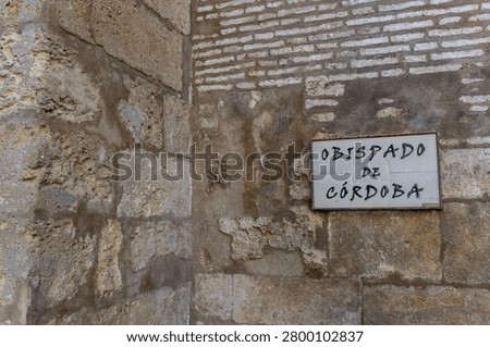 Close-up of an Ancient Weathered Stone Wall Featuring a Ceramic Sign Inscribed with 