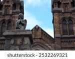 A close-up of an angel sculpture on the stone fence of St. Nicholas Church against the backdrop of the blue sky in the city of Kamianske, Ukraine