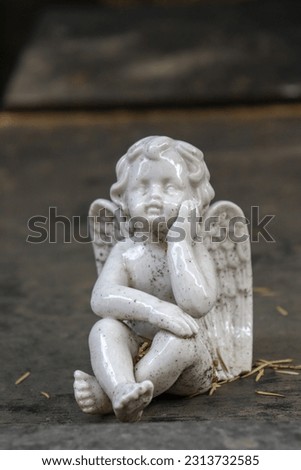 Close-up of angel sleeping in cemetery. Marble figurine on tombstone