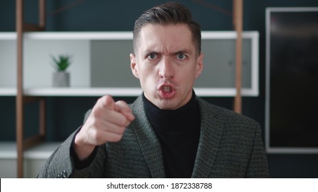 Close-up angry businessman shouting and pointing at camera. Portrait of aggresive boss scolding and shouting at employees threatening with a finger and shouting at the camera. - Powered by Shutterstock