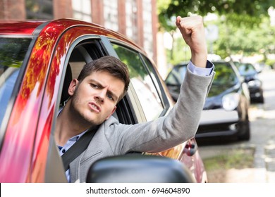 Close-up Of An Angry Man Looking Outside Car Window